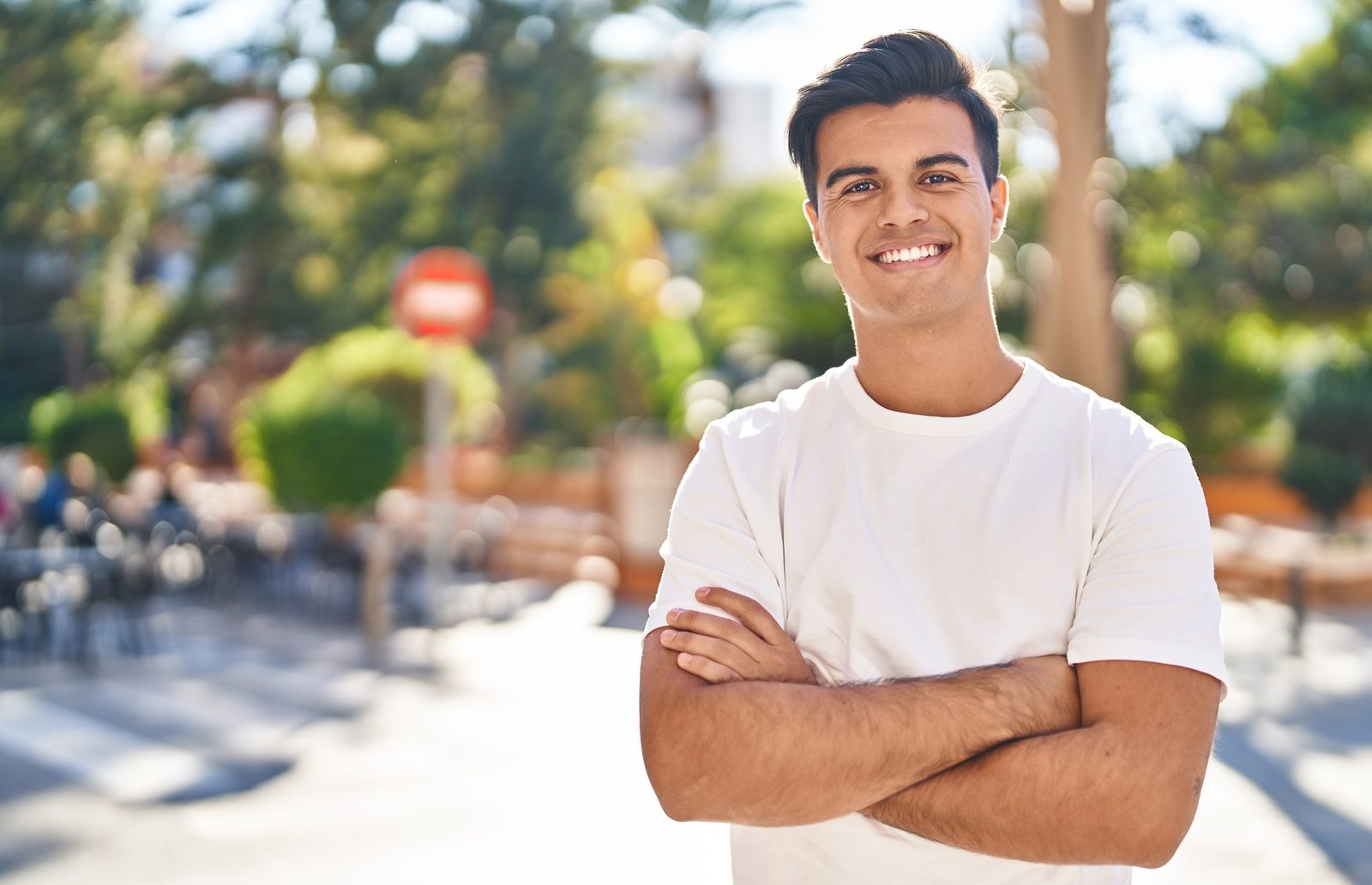 Smiling man outdoors in a sunny neighborhood