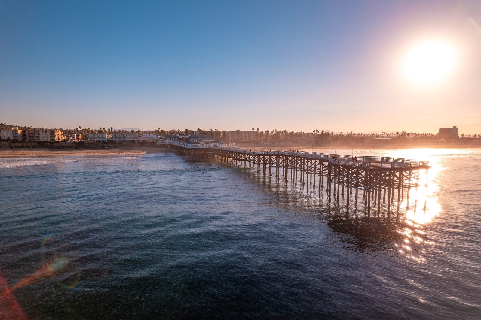 Sunlit Pacific Beach pier over the ocean